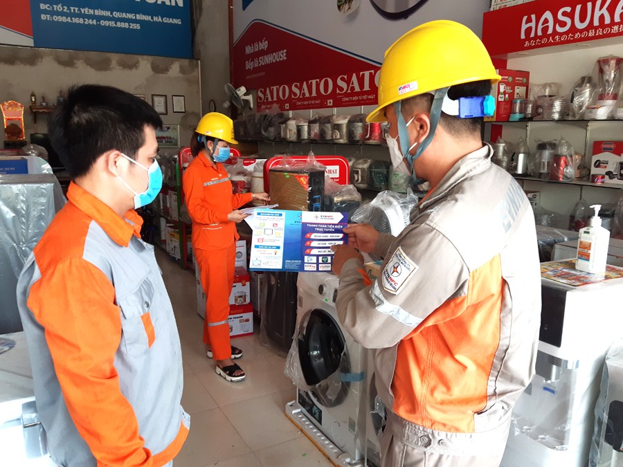 Cán bộ Điện lực Hà Giang hướng dẫn khách hàng sử dụng dịch vụ thanh toán tiền điện không dùng tiền mặt