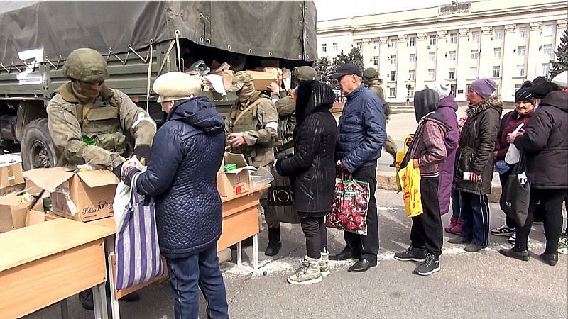 Binh sĩ Nga phân phát hàng hóa viện trợ cho cư dân Kherson. Ảnh: TASS