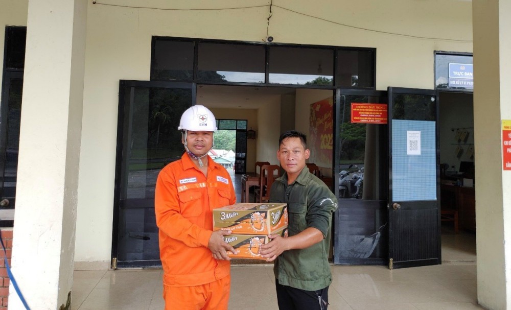 Anh Bh Nướch Vinh (bên trái) - nhân viên Phòng Hành chính và Lao động Công ty trao các thùng Mì tôm cho anh A Hó Ben, Trưởng thôn Dung – ngày 26.9.2022