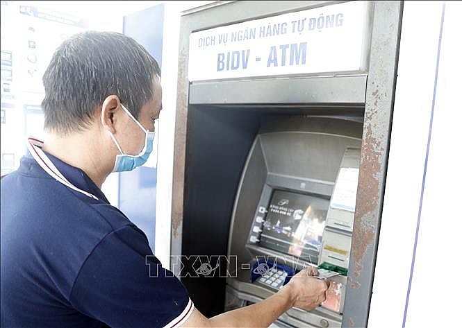 Người dân sử dụng thẻ nội địa tại máy rút tiền tự động của BIDV.