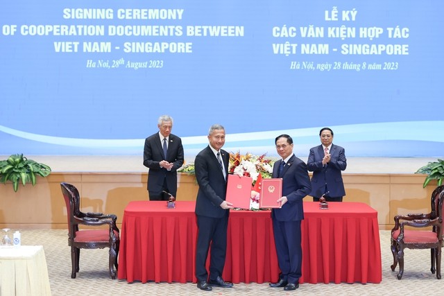 Bộ trưởng Bộ Ngoại giao Bùi Thanh Sơn (ngồi, phải) và Bộ trưởng Bộ Ngoại giao Singapore Vivian Balakrishnan (ngồi, trái) ký thỏa thuận hợp tác