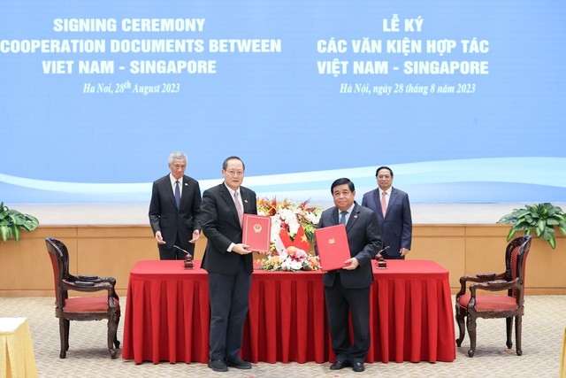 Bộ trưởng Bộ Kế hoạch và Đầu tư Nguyễn Chí Dũng (phải) và Bộ trưởng Bộ Nhân lực kiêm Bộ trưởng thứ hai Bộ Công Thương Singapore Tan See Leng (trái) ký Công thư trao đổi về việc sửa đổi Hiệp định Khung Kết nối hai nền kinh tế Việt Nam - Singapore (năm 2005)