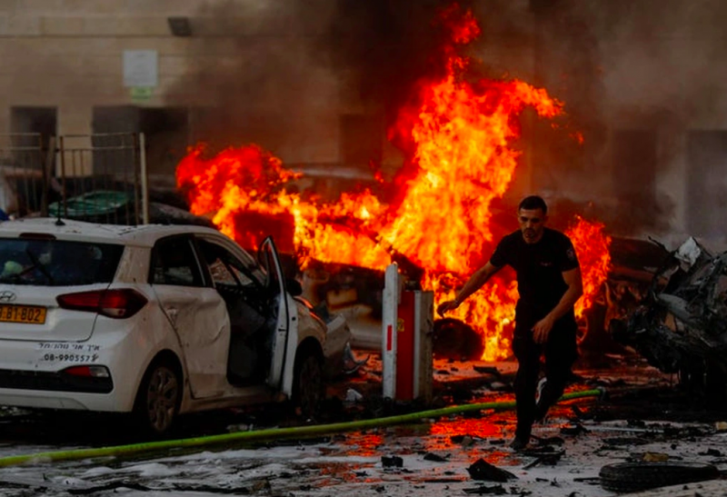 Trên đường phố Israel, khung cảnh khói lửa đổ nát tan hoang với hàng loạt xe hơi bốc cháy, nhiều người thương vong (Ảnh: Reuters).