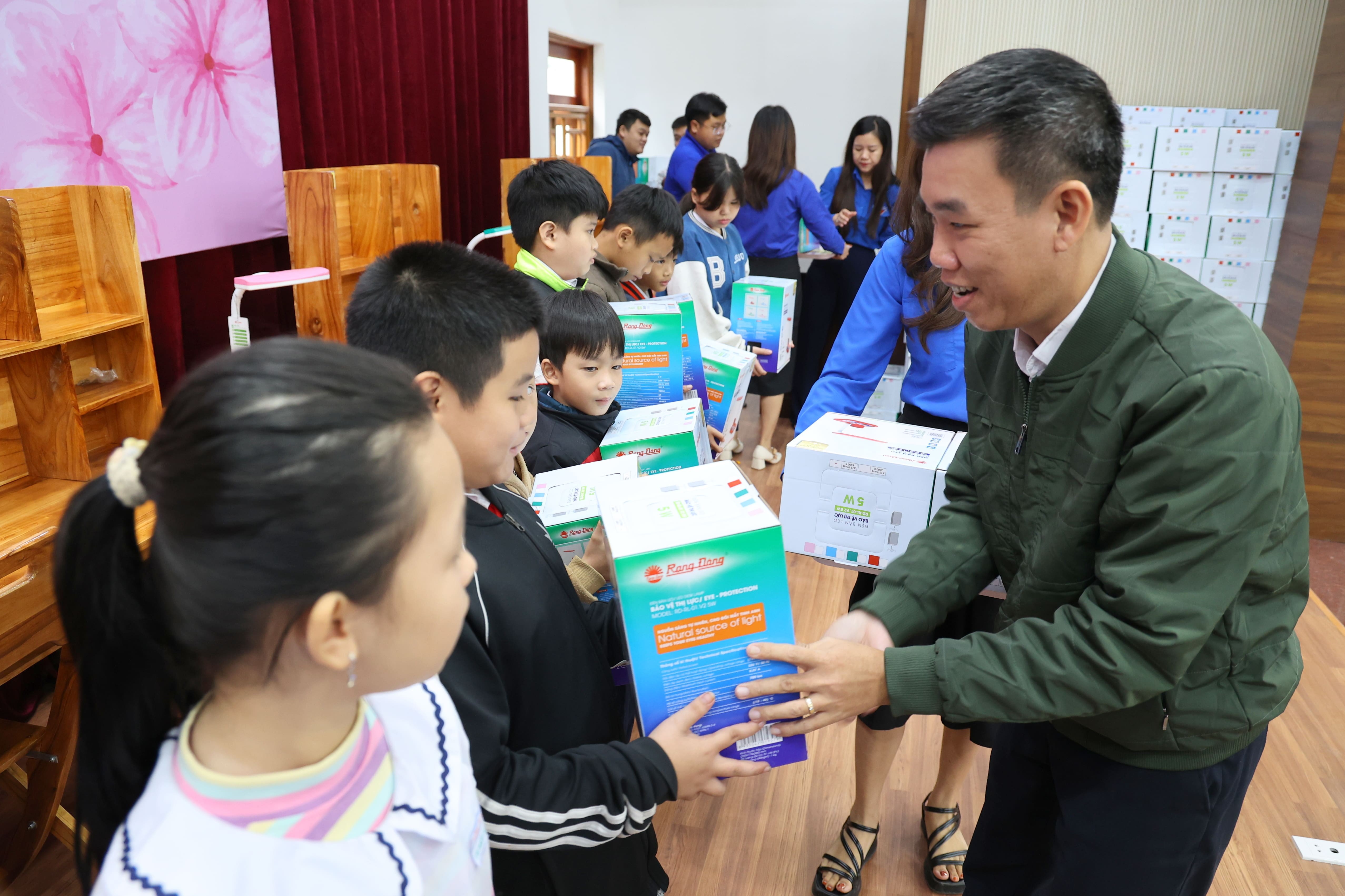 Ông Nguyễn Binh Nam - Phó Bí thư Thường trực Đảng ủy, Trưởng Ban Truyền thông EVNCPC trao tặng đèn học và góc học tập cho các em