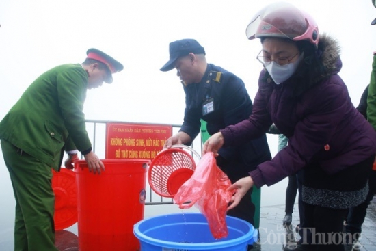 Lực lượng công an hỗ trợ người dân đưa cá chép ra sông tiễn ông Công, ông Táo về trời