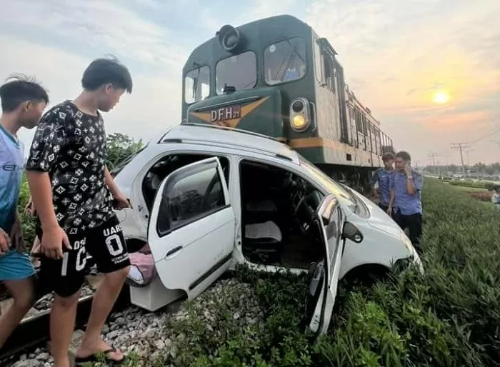 Tàu hỏa "vò nát" xe con trên đường sắt, người dân tức tốc cứu 2 cha con gặp nạn