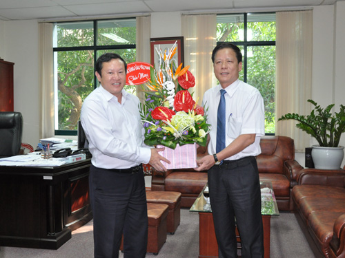 Tổng biên tập Báo Công Thương Nguyễn Hữu Quý (trái) nhận lẵng hoa chúc mừng.