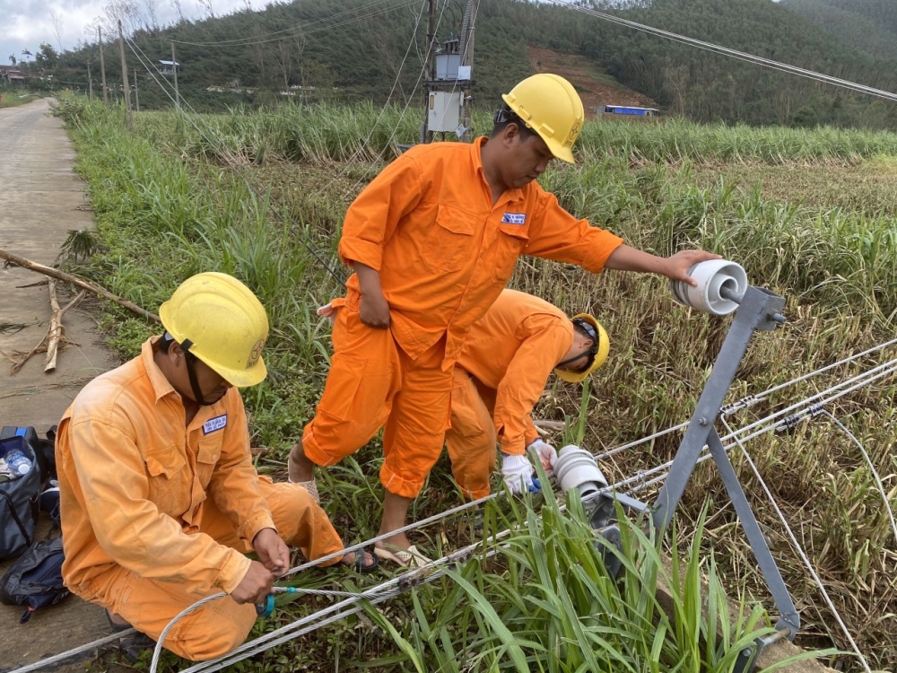 Công nhân vất vả khắc phục sự cố về điện do bão lũ ở miền Trung