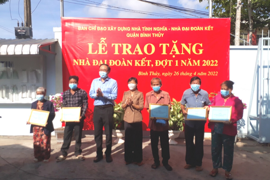 Ông Nguyễn Duy Lăng (thứ ba từ trái sang) trao bảng biểu trưng nhà đại đoàn kết cho các hộ gia đình