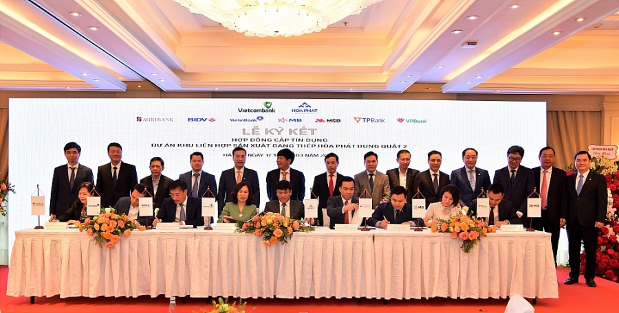 Ông Mai Văn Hà – Giám đốc Công ty CP thép Hòa Phát Dung Quất (ngồi thứ 5 từ trái sang) và đại diện 8 ngân hàng do Vietcombank làm đầu mối đồng tài trợ ký kết Hợp đồng tín dụng