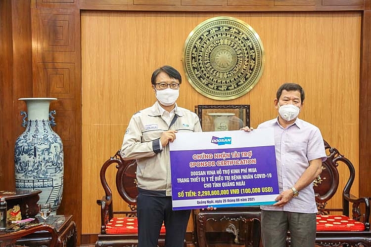 TGĐ Doosan Vina Jeong Young Chil (trái) trao biểu trưng hỗ trợ số tiền gần 2,3 tỉ đồng cho Chủ tịch UBND tỉnh Quảng Ngãi Đặng Văn Minh